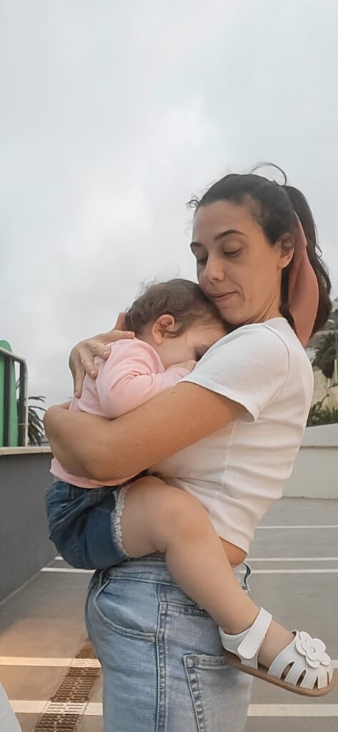 Madre abrazando con ternura a su hija pequeña en un momento de conexión y amor, representando la esencia de la crianza consciente